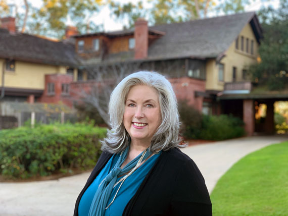 Photo of Robin Lakin, in front of the porte cochere at the Marston House