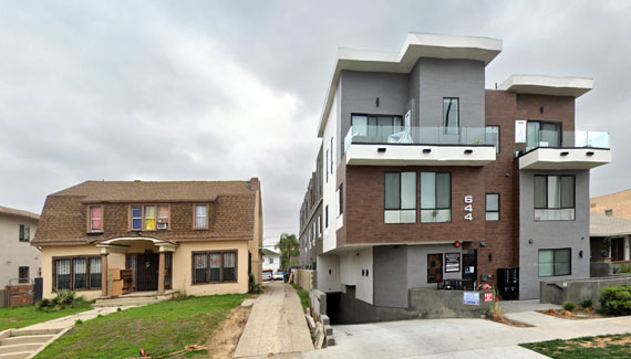 Photo of older home flanked by new 6-pack development.