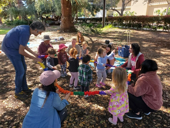 Photo of children enjoying the ChIMES program under the oak tree at the Marston House